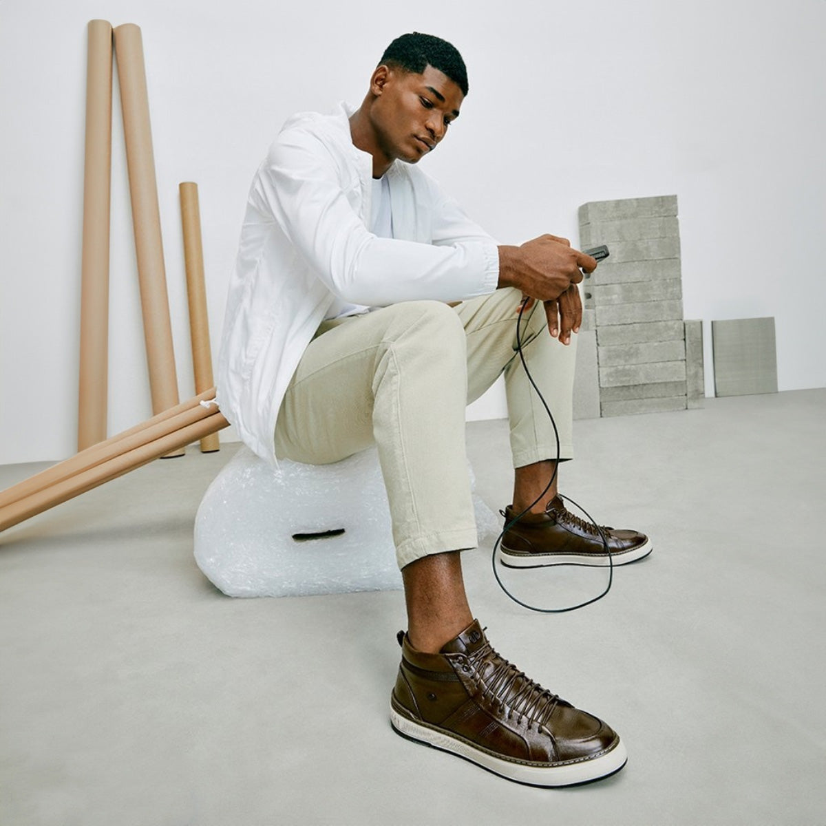 man wearing democrata shoes in white pastel setting