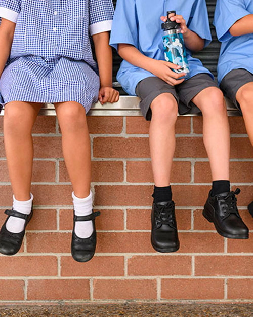 school kids sitting on a wall